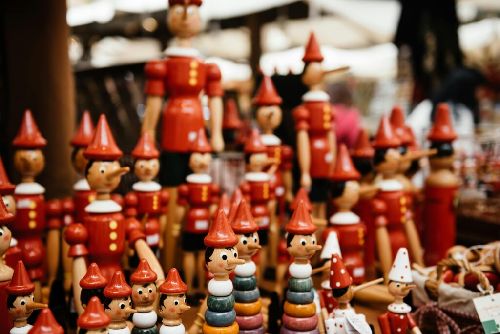 Close-up of handmade wooden Pinocchio toys at a market. Perfect for traditional and souvenir themes.